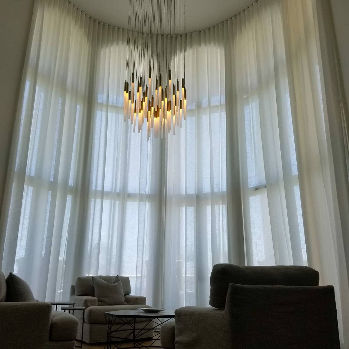 Double-height sheer curtains with chandelier